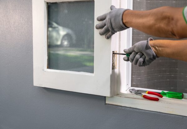 Construction,Worker,Repairing,The,Window,Hinge,After,Storm.