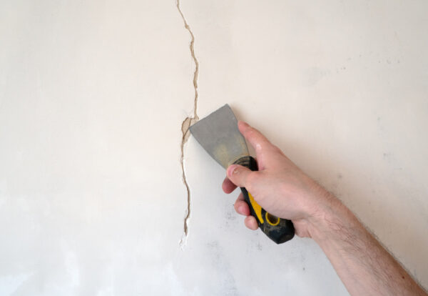 Construction,Man,Worker,Repairing,A,Crack,Wall,Of,A,Home,