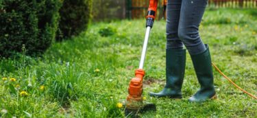 Woman,Cutting,Grass,At,Backyard.,Electric,Grass,Trimmer.,Lawn,Care