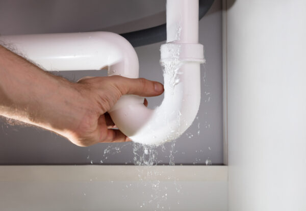 Close-up,Of,A,Man's,Hand,Holding,The,Leakage,White,Sink