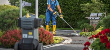 A,Worker,In,Blue,Overalls,And,Yellow,Boots,Cleans,A